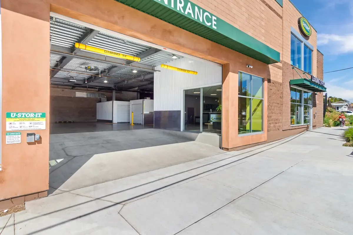 Covered drive-in loading bay entrance at a self-storage facility featuring clear height clearance bars.