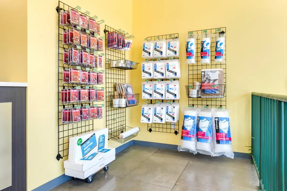 Self-storage office retail wall displaying locks, bubble wrap, mattress covers, and moving supplies.