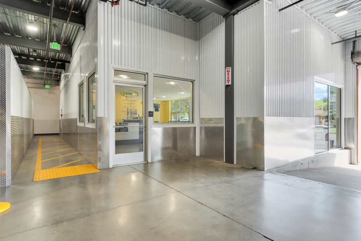 Glass entrance door to a U-Stor-It rental office with diamond plate trim and polished concrete floor.
