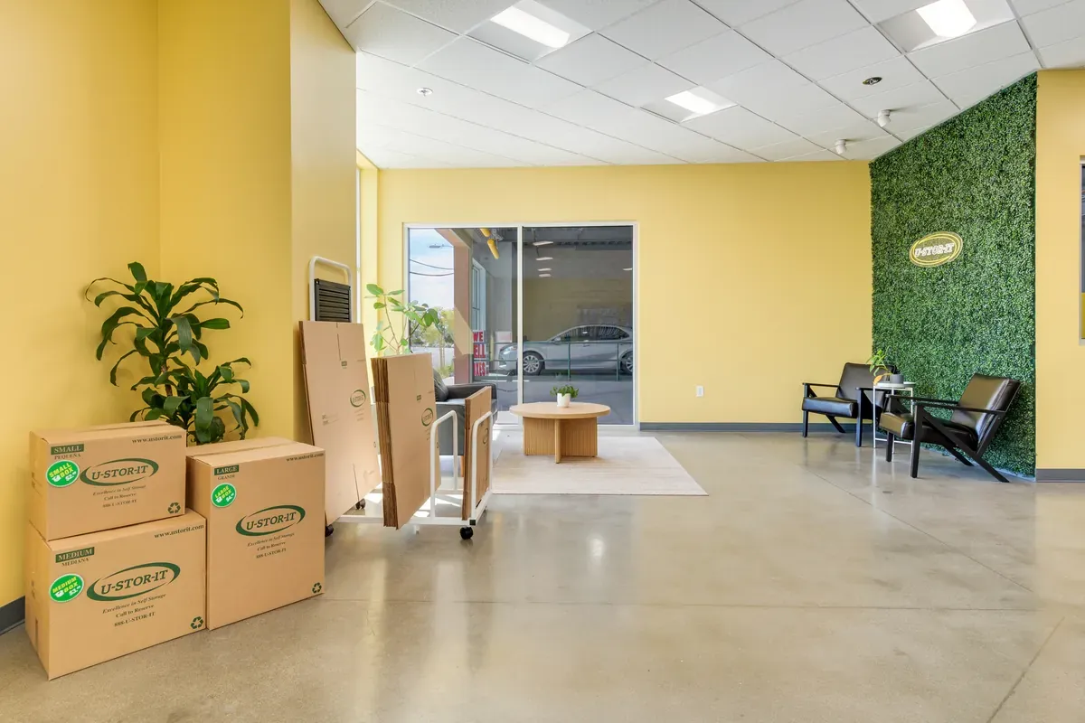 Self-storage office lobby featuring a box display rack, customer seating area, and polished concrete floors.