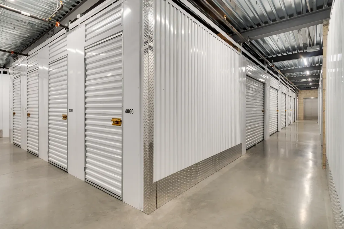 Indoor climate-controlled self-storage unit with a white roll-up door and diamond plate trim.