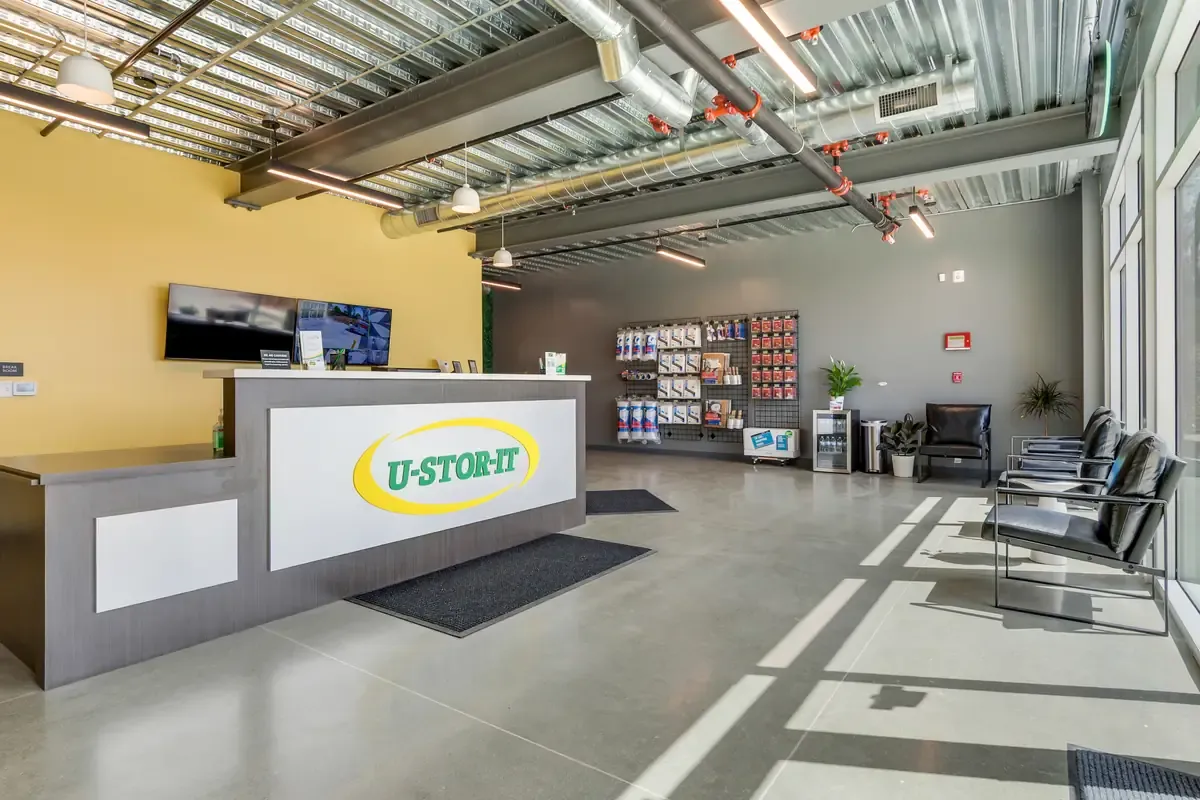 Modern U-Stor-It customer service counter with packing supplies and moving inventory on wall displays.